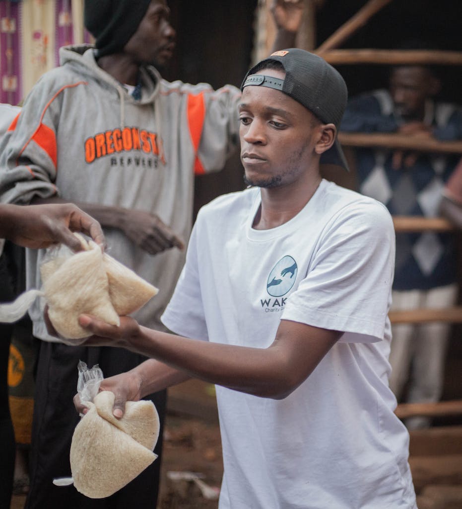 Young volunteers distribute food packs to community members during a charity event.